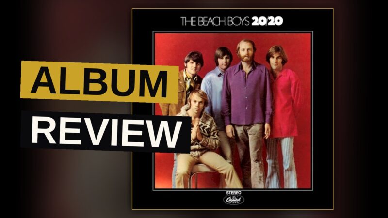 A vintage vinyl record and sun-faded album cover on a wooden table, evoking a nostalgic 1960s music mood.