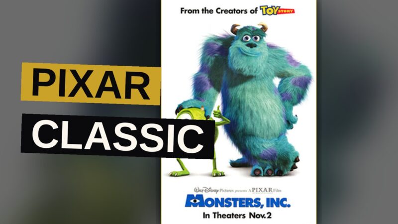 A large blue monster holds a laughing child while a small green one-eyed monster stands beside them in a bedroom.