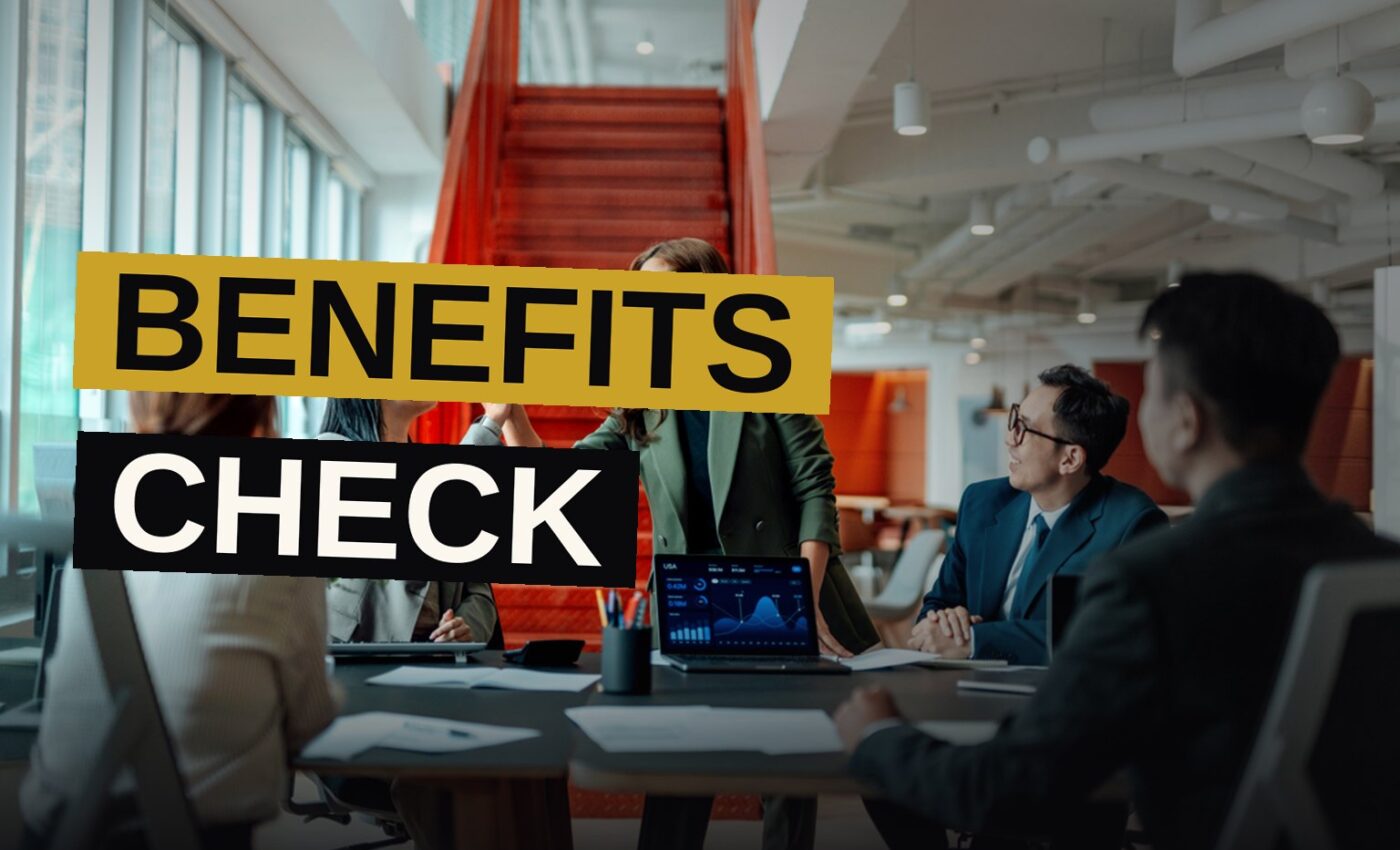 A desk scene with a laptop, coffee, and a checklist, illustrating workplace benefits review.