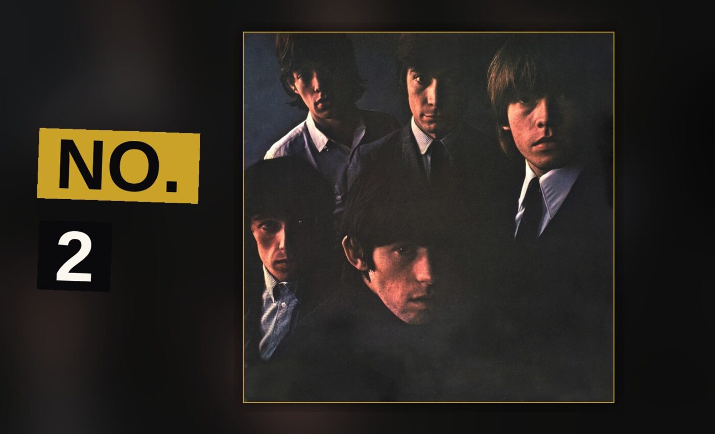 A band performs energetically on a dimly lit stage, guitars raised, in a raw 1960s rock setting.