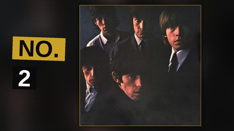 A band performs energetically on a dimly lit stage, guitars raised, in a raw 1960s rock setting.