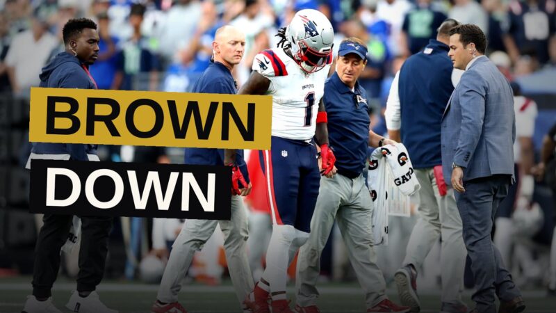 A.J. Brown lies on the field after injuring his ankle, surrounded by Patriots teammates and medical staff.