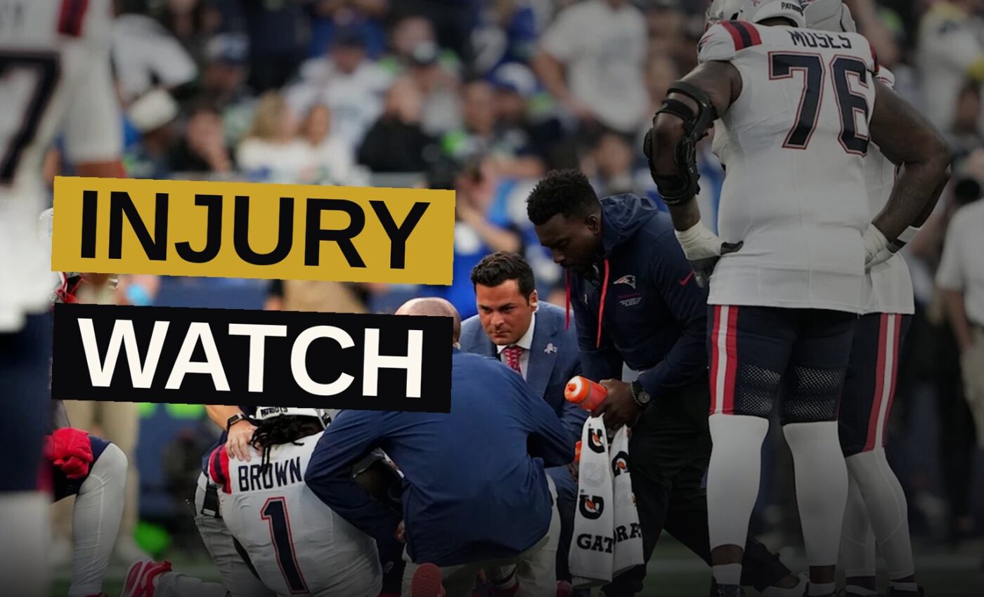 A New England Patriots wide receiver sits on the sideline wearing a walking boot after an ankle injury.