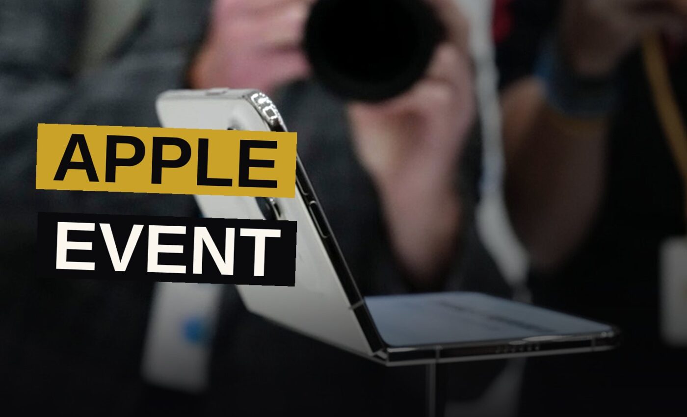 A foldable smartphone half-open on a dark stage with spotlights and bokeh, evoking a high-tech keynote.