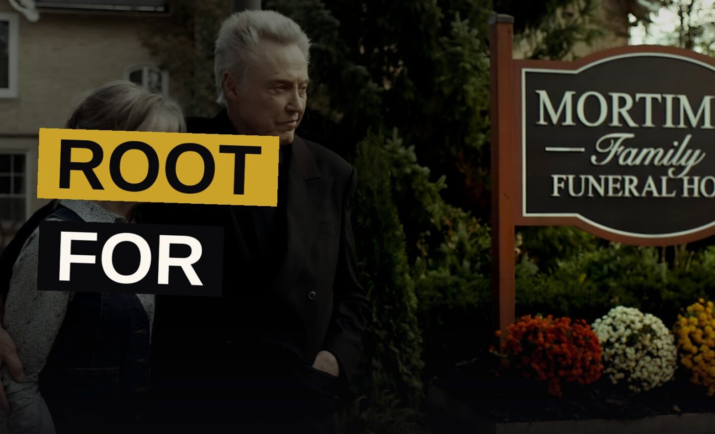 An old man and a young woman stand silently together in a dim funeral home, evoking a tale of dread and affection.