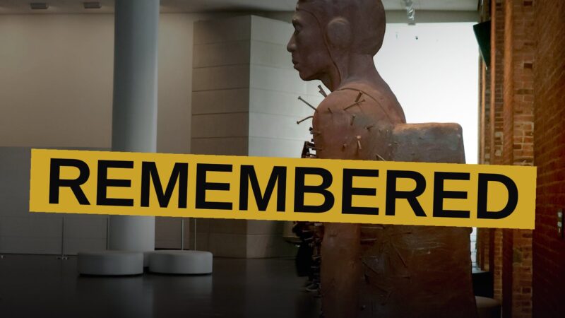 A sculpture of a Black military pilot pierced by nails stands on a pedestal in the Brooklyn Museum's bright lobby.