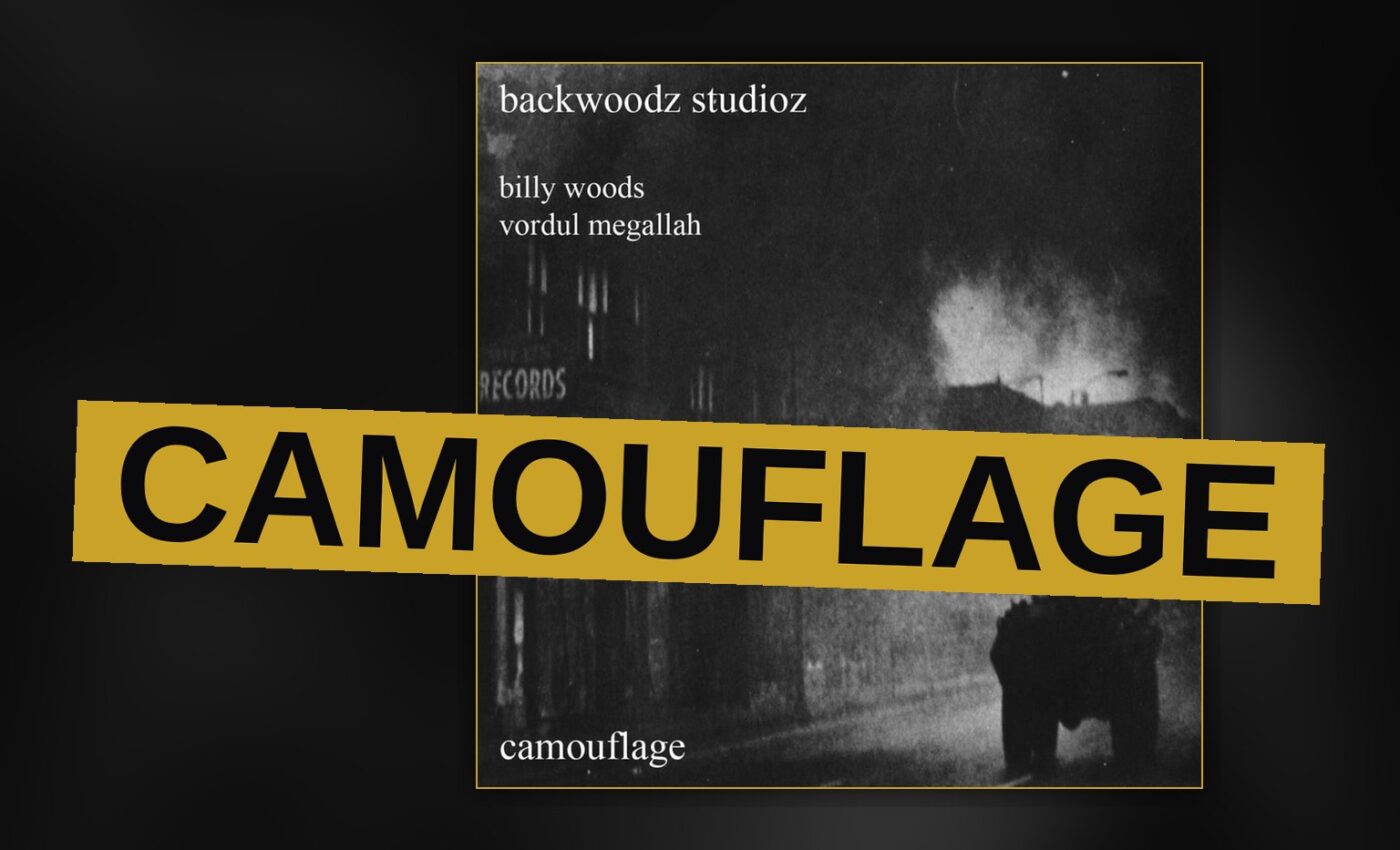 A man in camouflage stands on a rooftop overlooking a neon-lit city street at dusk.