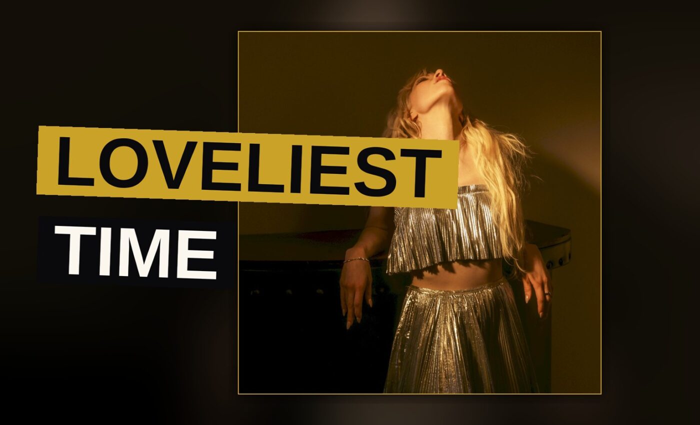 A singer stands under colored stage lights amid swirling haze, evoking a dreamy pop concert.