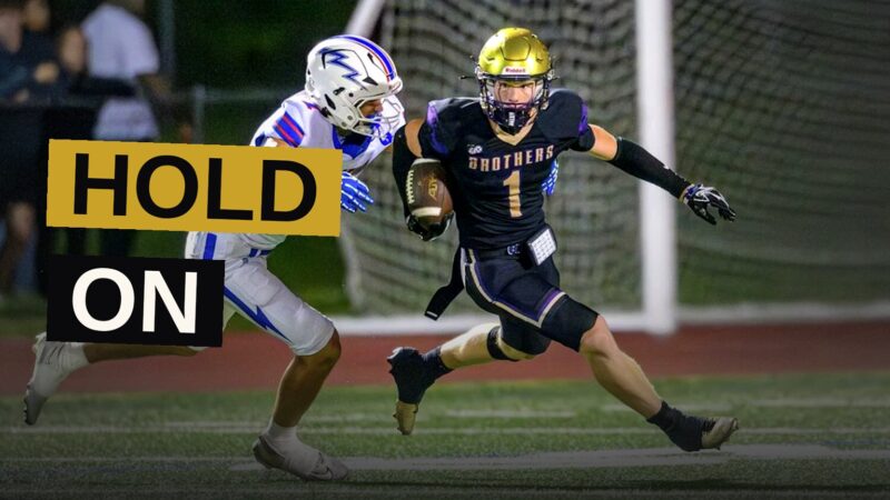 A football player makes a spin move to evade a tackler during a long punt return.