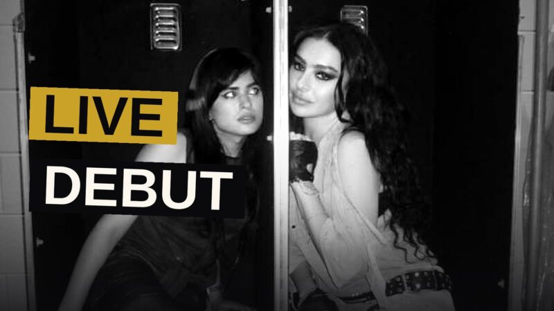 Charli XCX performs on stage with dramatic lighting during her Music, Fashion, Film tour opener.
