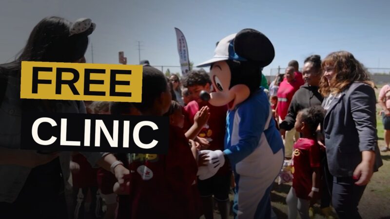 Children play various sports at a park while Disney characters watch from nearby.