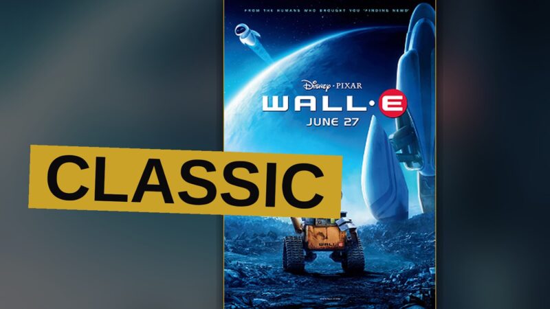 WALL-E, a small rusty robot, stands in a trash-covered desert with a green sprout growing from a boot at his feet.