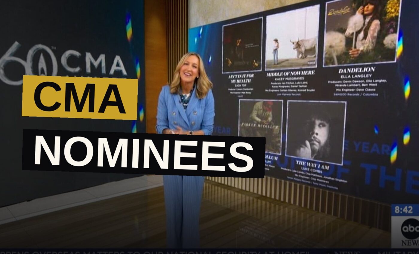 A country music award ceremony stage with golden lights and a large screen showing the 60th CMA Awards logo.