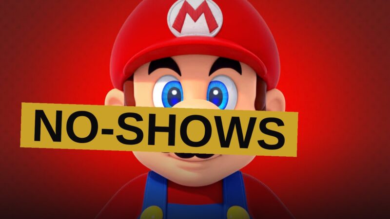 A dark stage with an empty spotlight and a Nintendo Switch 2 controller, surrounded by ghostly silhouettes and a question mark.