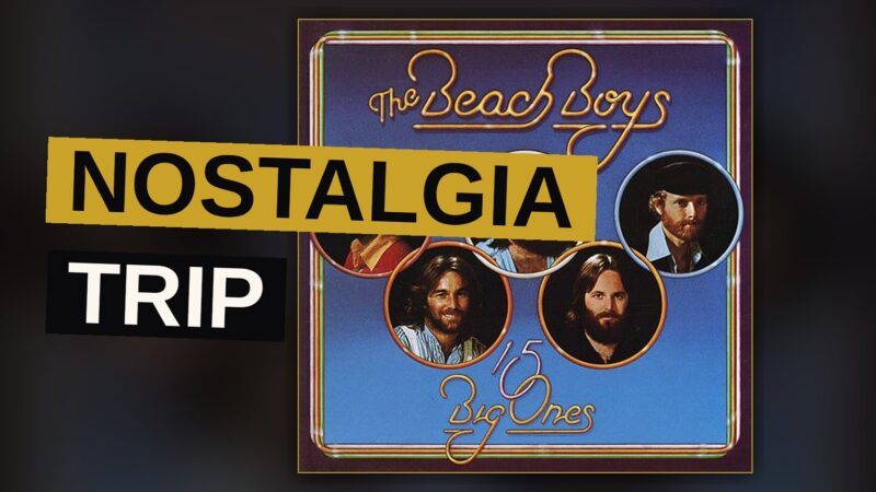 A vintage record player plays a Beach Boys album in a dimly lit room with retro decor.