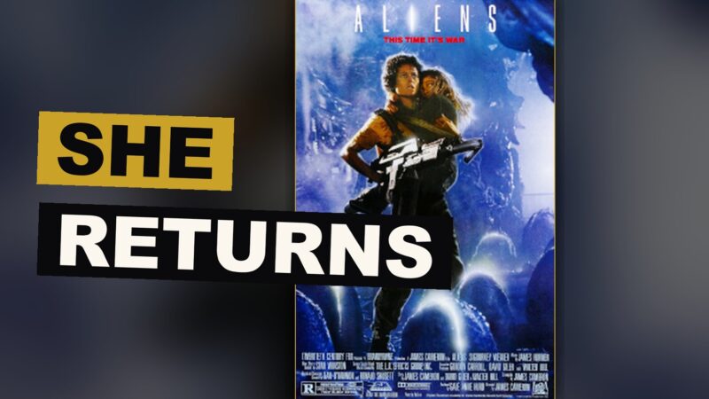 A woman in a heavy metal suit stands ready in a dim chamber, facing an unseen creature.