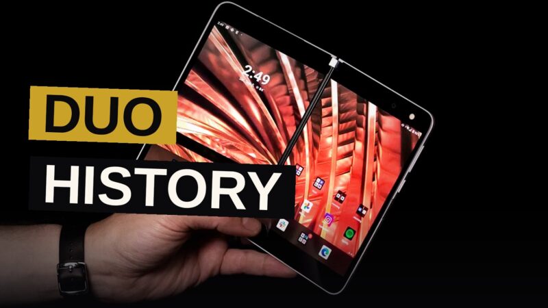 A modern foldable smartphone with a subtle screen crease sits next to a shadowy display of older Duo-branded devices.