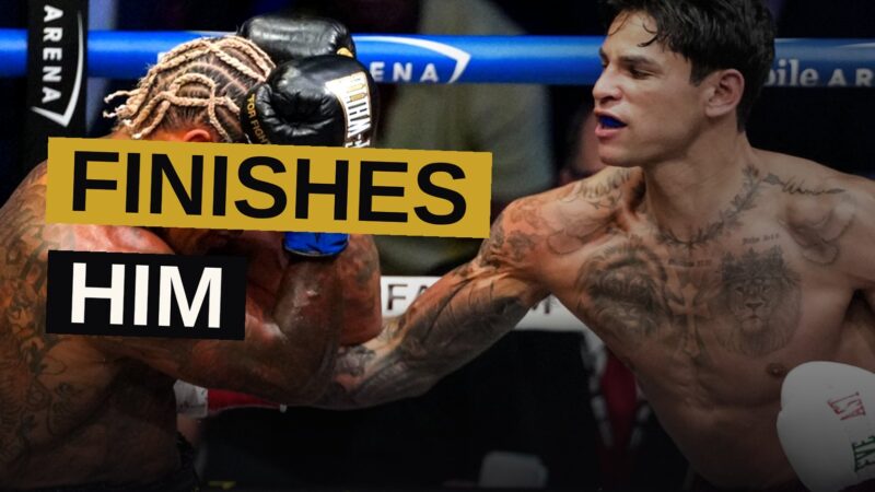 A boxer raises his arms in triumph in the ring after defeating his opponent.
