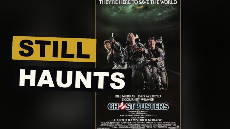 A giant pale creature rises above a haunted city street as four figures with strange devices upon their backs stand ready.