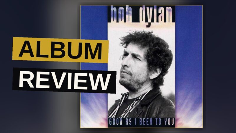 An acoustic guitar and harmonica in a dim garage, evoking a solo folk session.