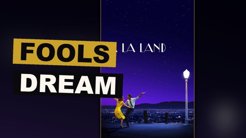 A man and woman dance together against a bright, colored sky above a city of lights.