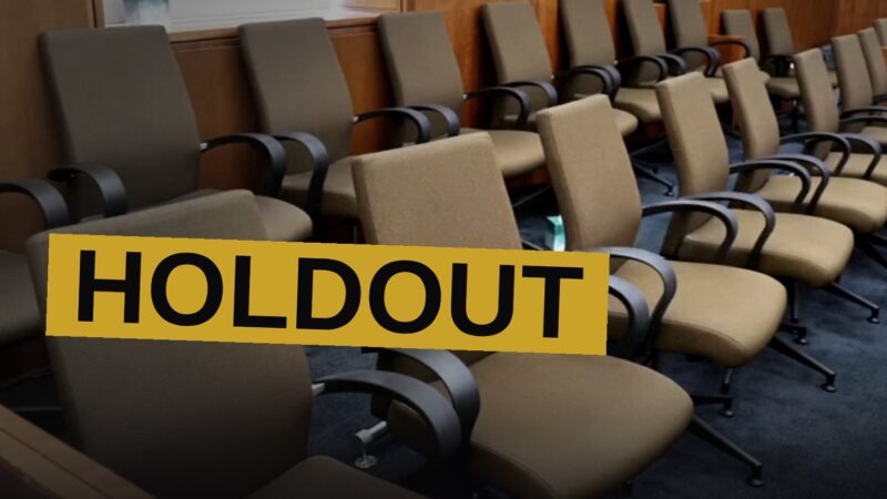 An empty jury box sits within a solemn chamber, the scene heavy with doubt and sorrow.