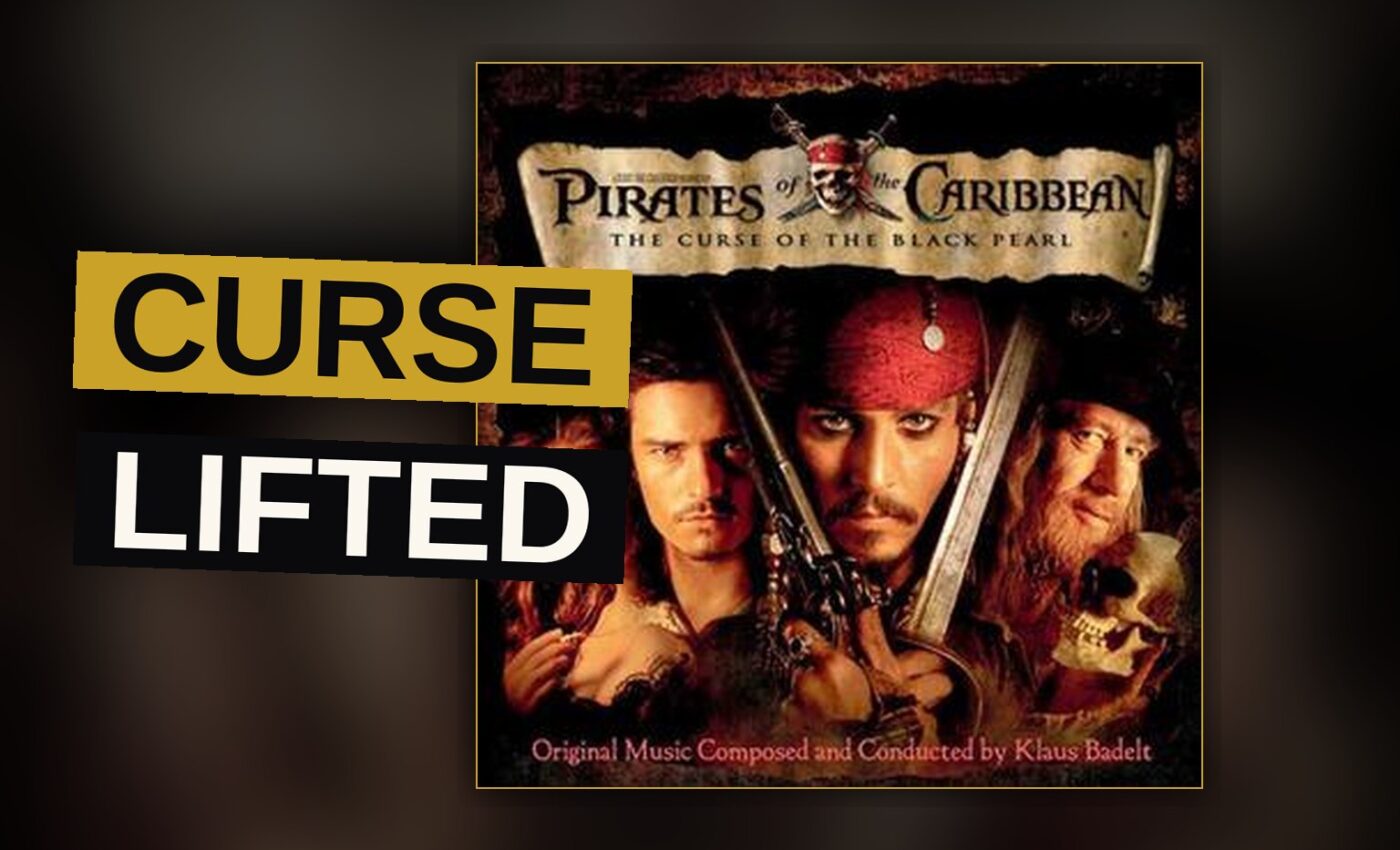 Jack Sparrow with a sword faces skeleton pirates on a moonlit beach.