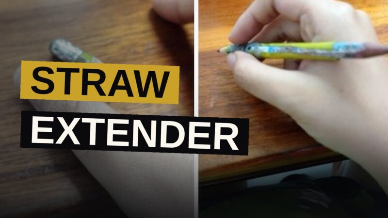 A tiny pencil is inserted into a straw, taped together on a desk beside a notebook.
