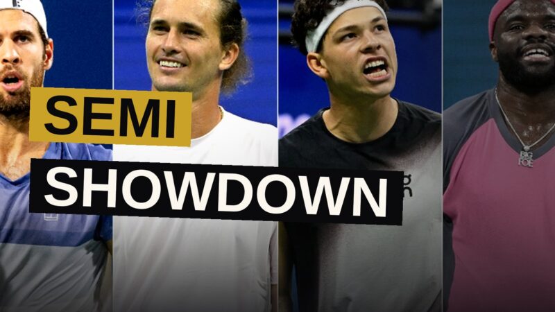 Two tennis players face off under floodlights in a packed stadium at night.
