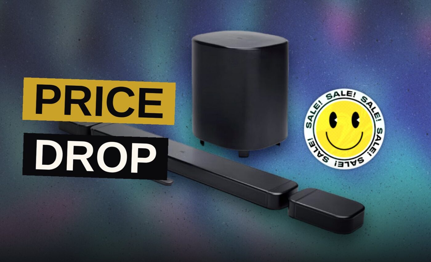 A dark soundbar rests beneath a glowing television, its wireless companions set apart upon the floor.