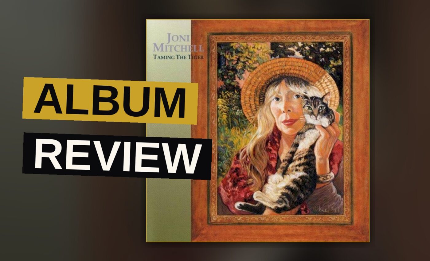 Joni Mitchell plays an acoustic guitar in a dimly lit studio, her expression contemplative and the lighting warm and soft.
