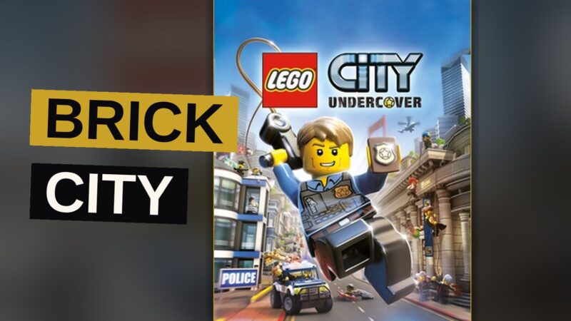 A masked hero drives a toy car through a brightly colored city of plastic bricks.