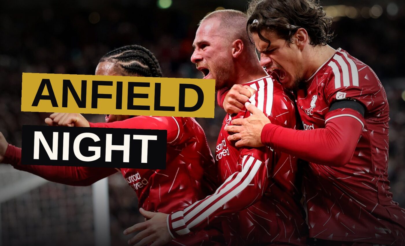 Liverpool players in red react after scoring a goal at Anfield during a night match.