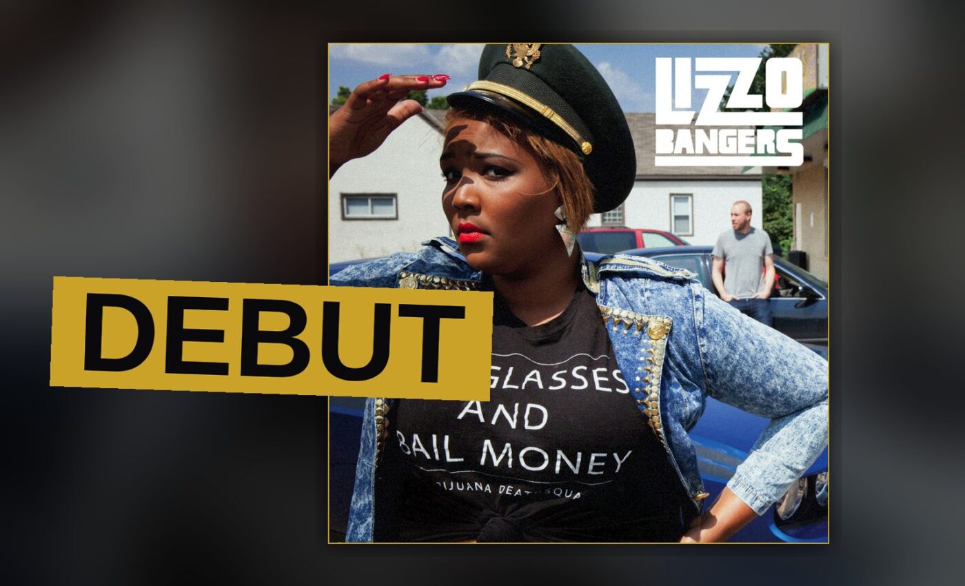 A confident young rapper stands bathed in stage light, exuding energy and personality.