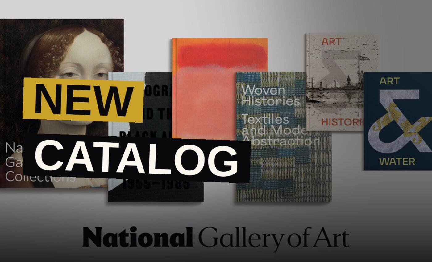 An open art book sits upon a desk amid small scholarly objects, bathed in warm light.