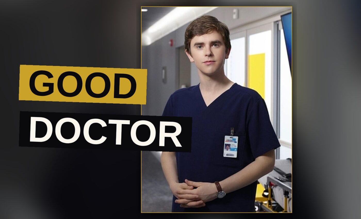 A young man dressed in a white coat stands in a dimly lit hospital hallway.