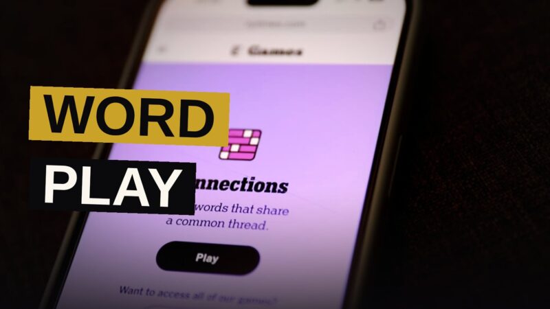 A smartphone displaying a word puzzle grid, surrounded by paper cards with word definitions.