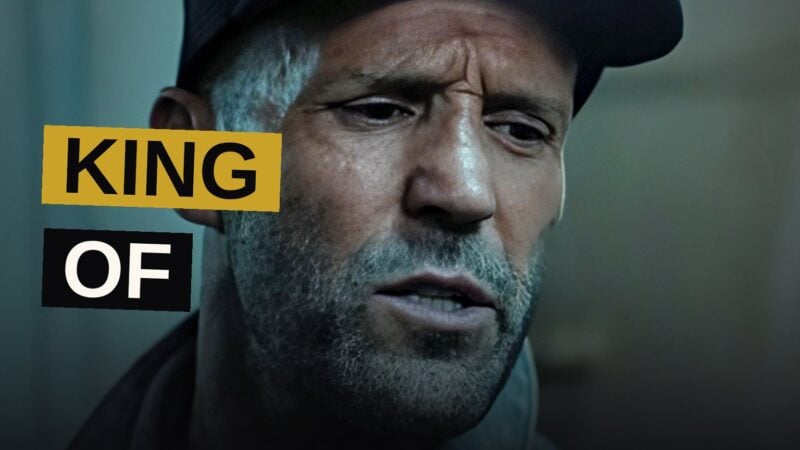 A rugged action star stands atop a city skyline, bathed in neon light, symbolizing his streaming triumph.
