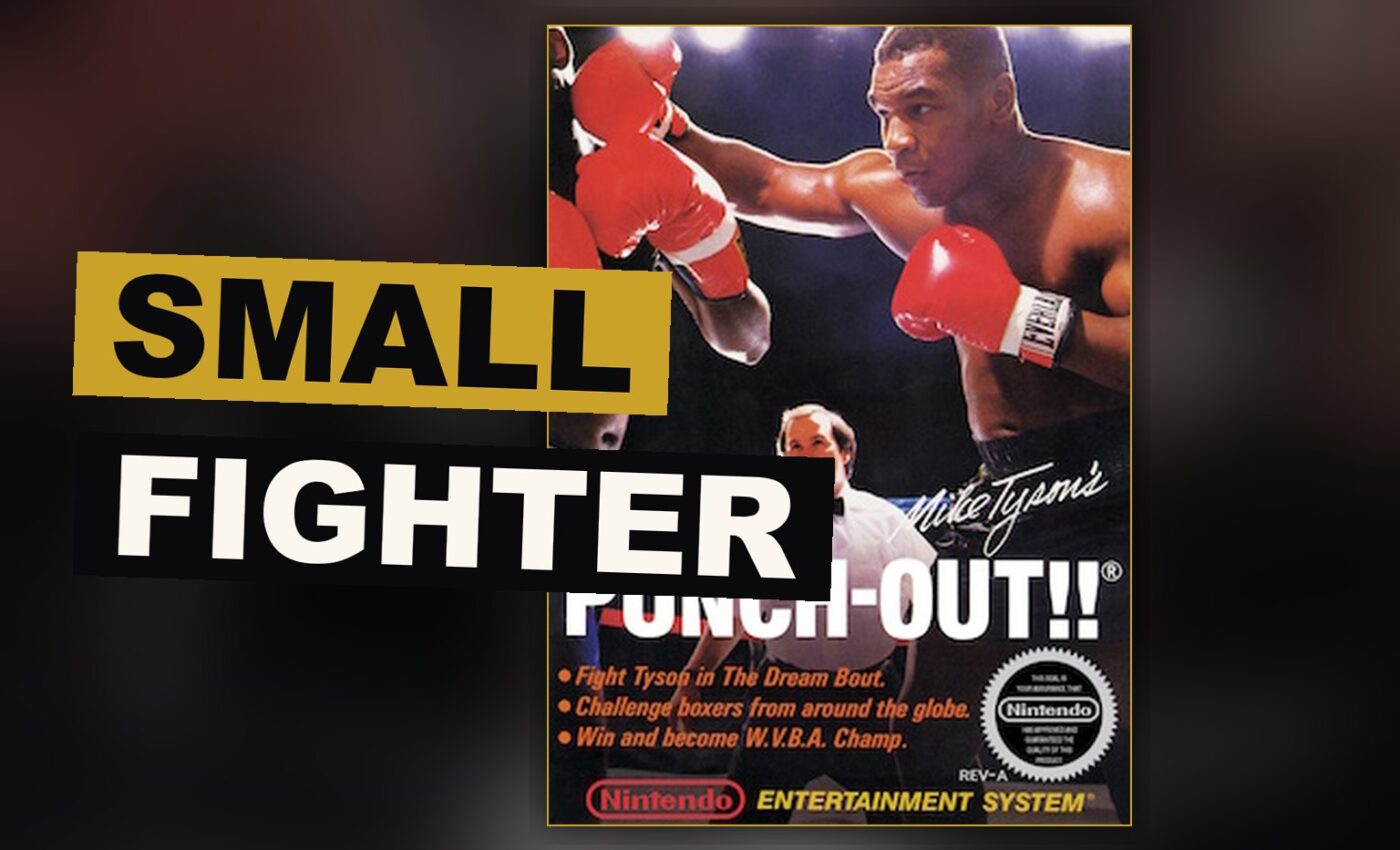 A small boxer squares off against a towering foe beneath the light of a solitary lamp within the ring.