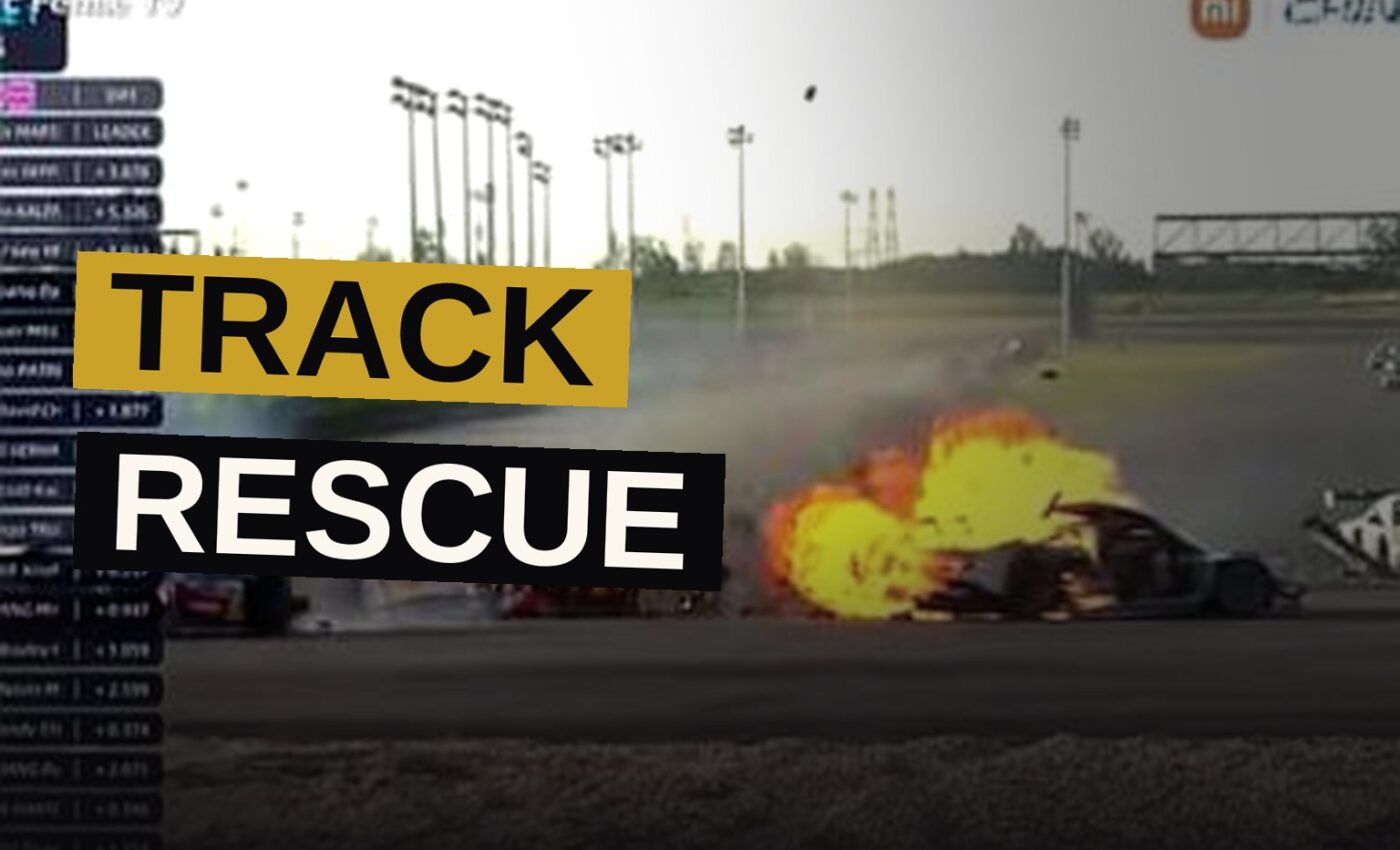A driver, with singular courage, draws a fellow racer from the fiery wreck of his burning car upon the track.