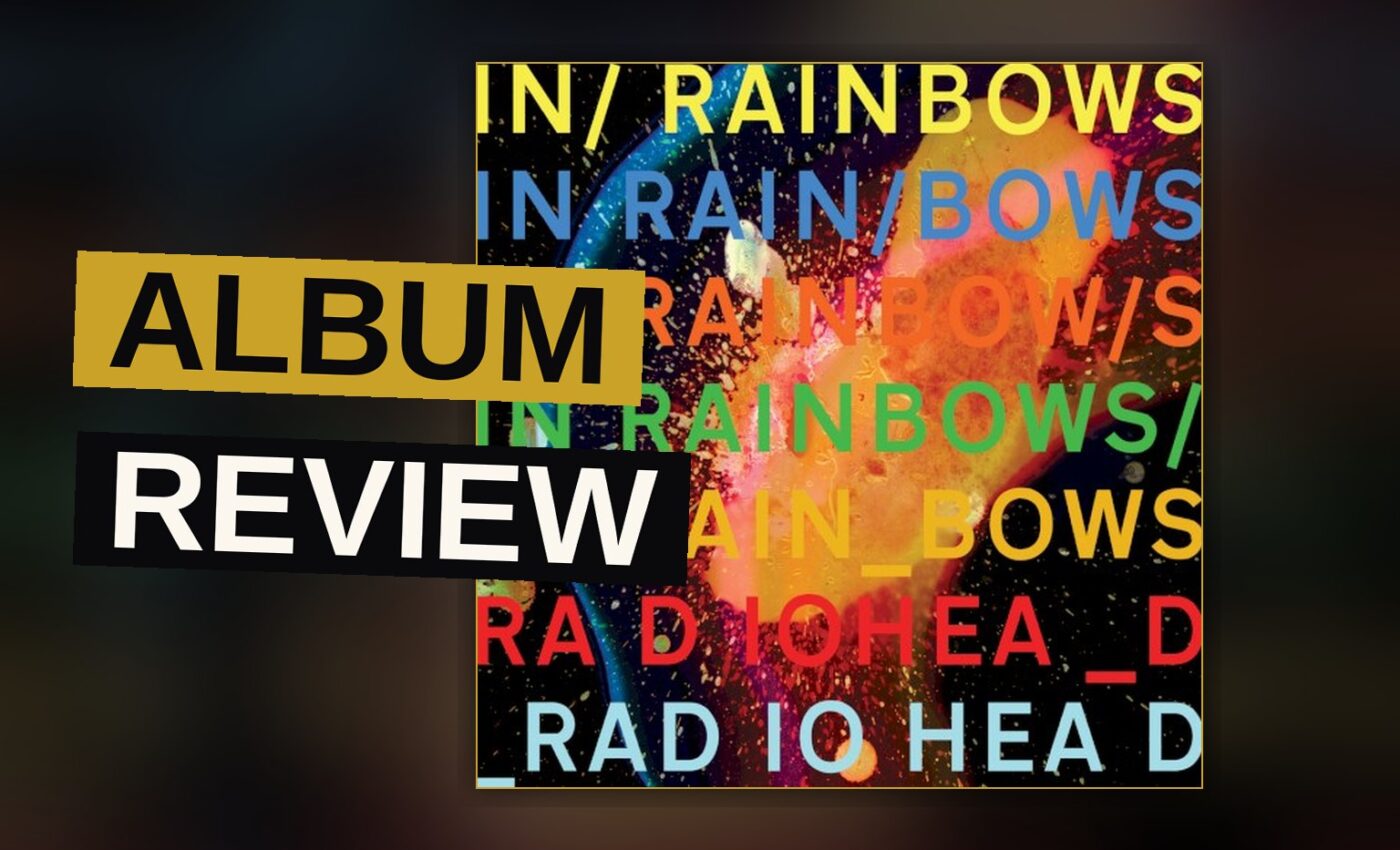 A vinyl record spinning on a player in warm, dim light, with a blurred album cover in the background.
