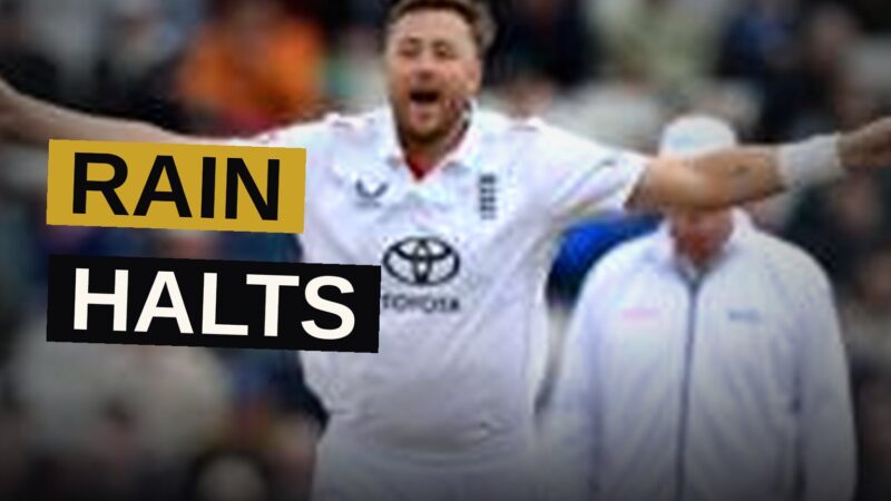 Cricket players walk off the field as rain falls and covers are placed on the pitch at Edgbaston.