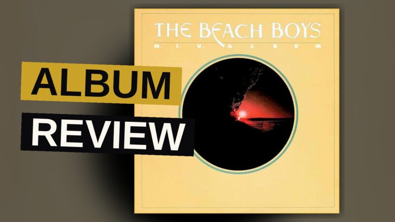 A sun-bleached album cover showing a beach with palm trees and a surfer, in warm faded colors.