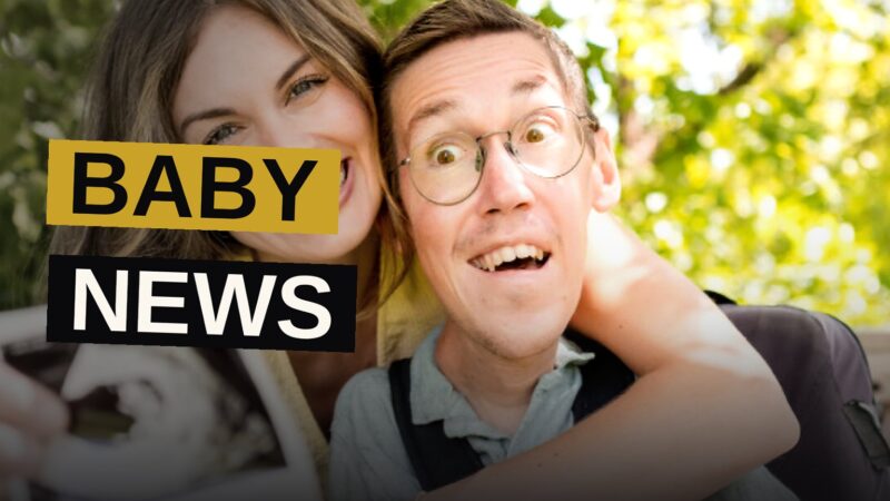 Shane and Hannah Burcaw smile together at home, Hannah cradling her baby bump, their dog nearby.