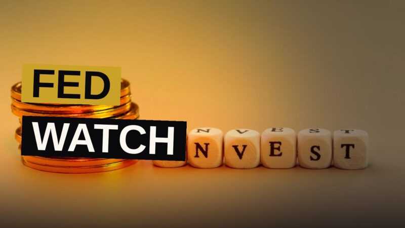 Gold bars and coins arranged near a financial chart representing interest rate uncertainty.