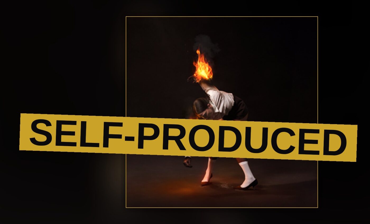 A silhouetted performer stands amid smoke and stage lights in a raw, industrial studio setting.