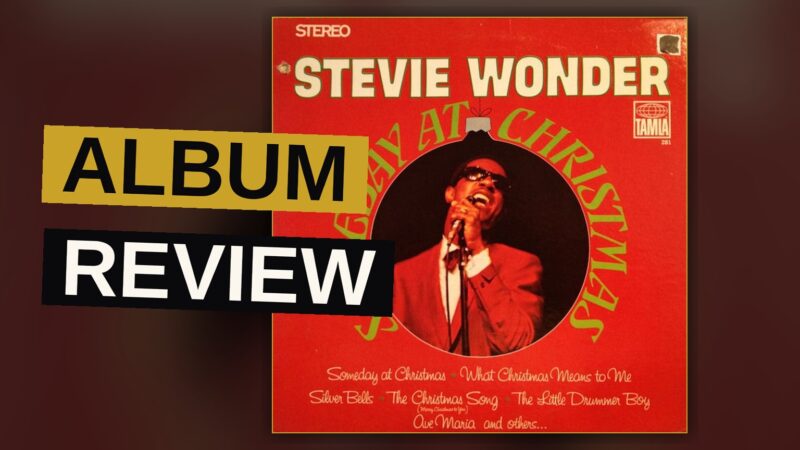 A vintage Christmas album cover with a young Stevie Wonder in a festive sweater, lit warmly in a studio.