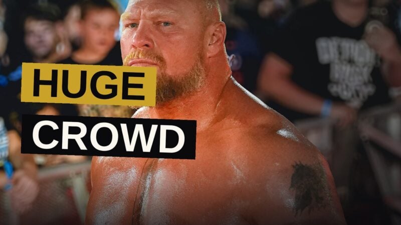 Two wrestlers struggle fiercely within the ring while a multitude watches in rapt attention.