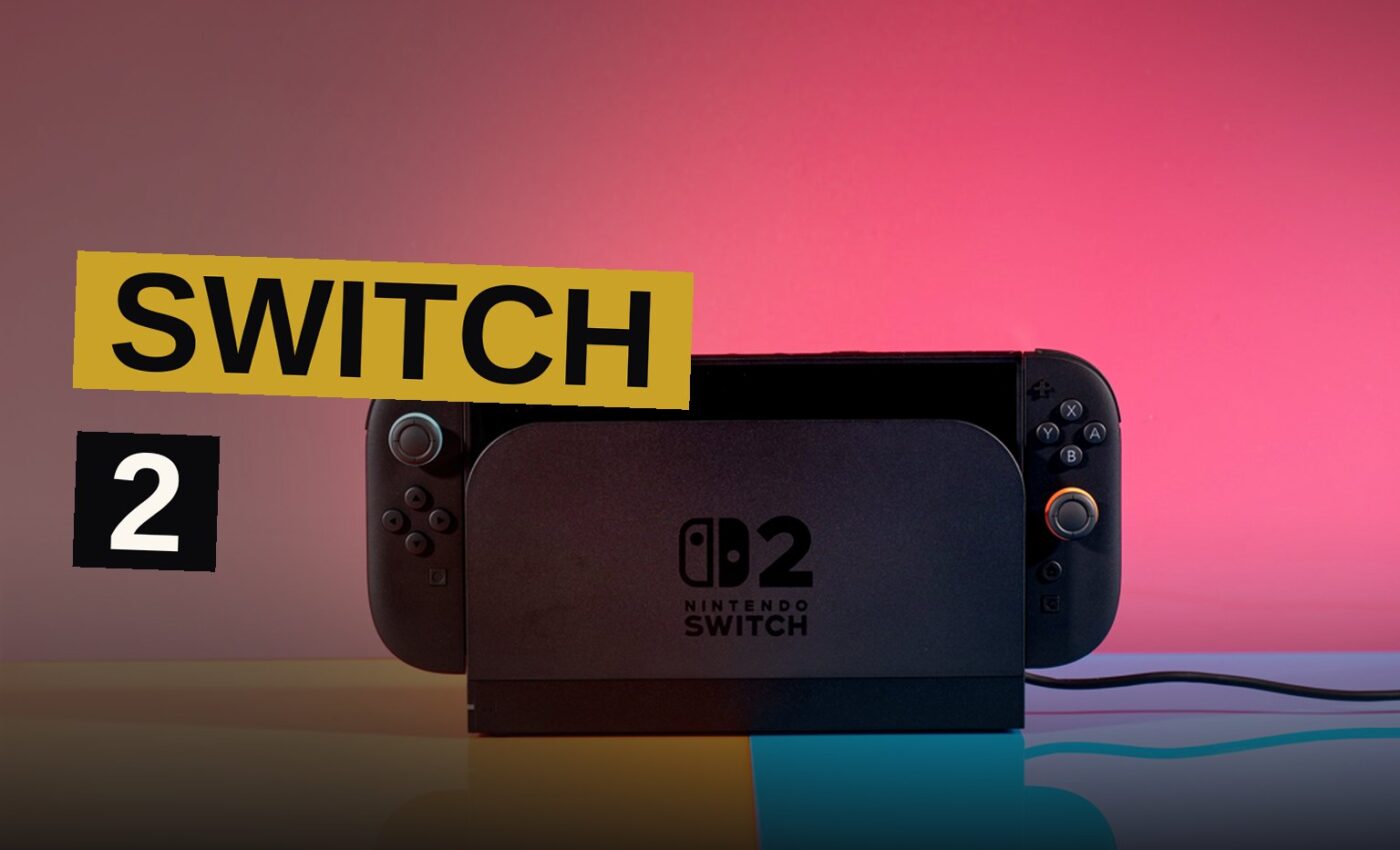 A Nintendo Switch 2 console in its dock connected to a large TV, with a colorful game displayed on the screen in a bright living room.