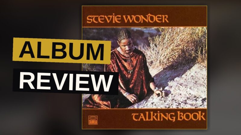 A vintage synthesizer keyboard bathed in warm amber light, with blurred vinyl records in the background, evoking a 1970s soul music mood.